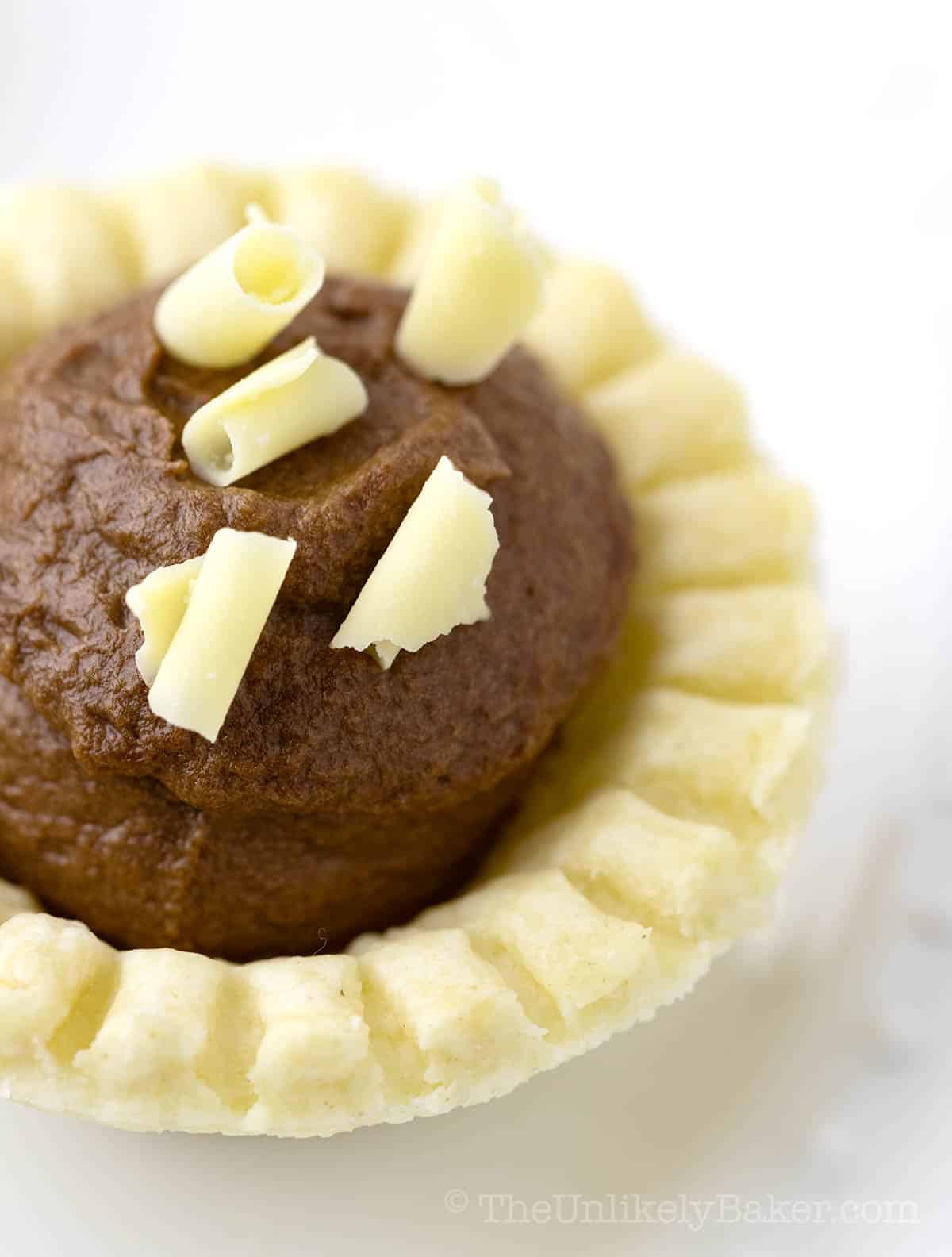 Chocolate tartlet on a plain background.