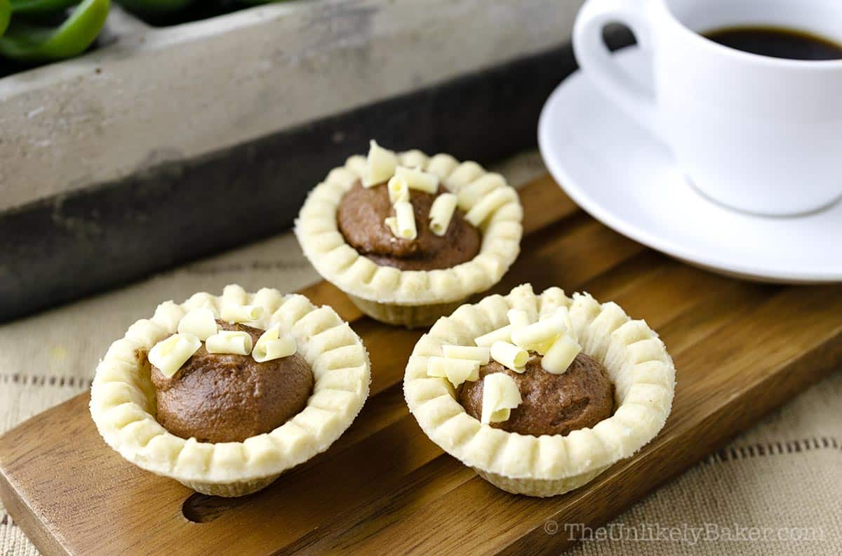 Individual chocolate tarts on a serving platter.