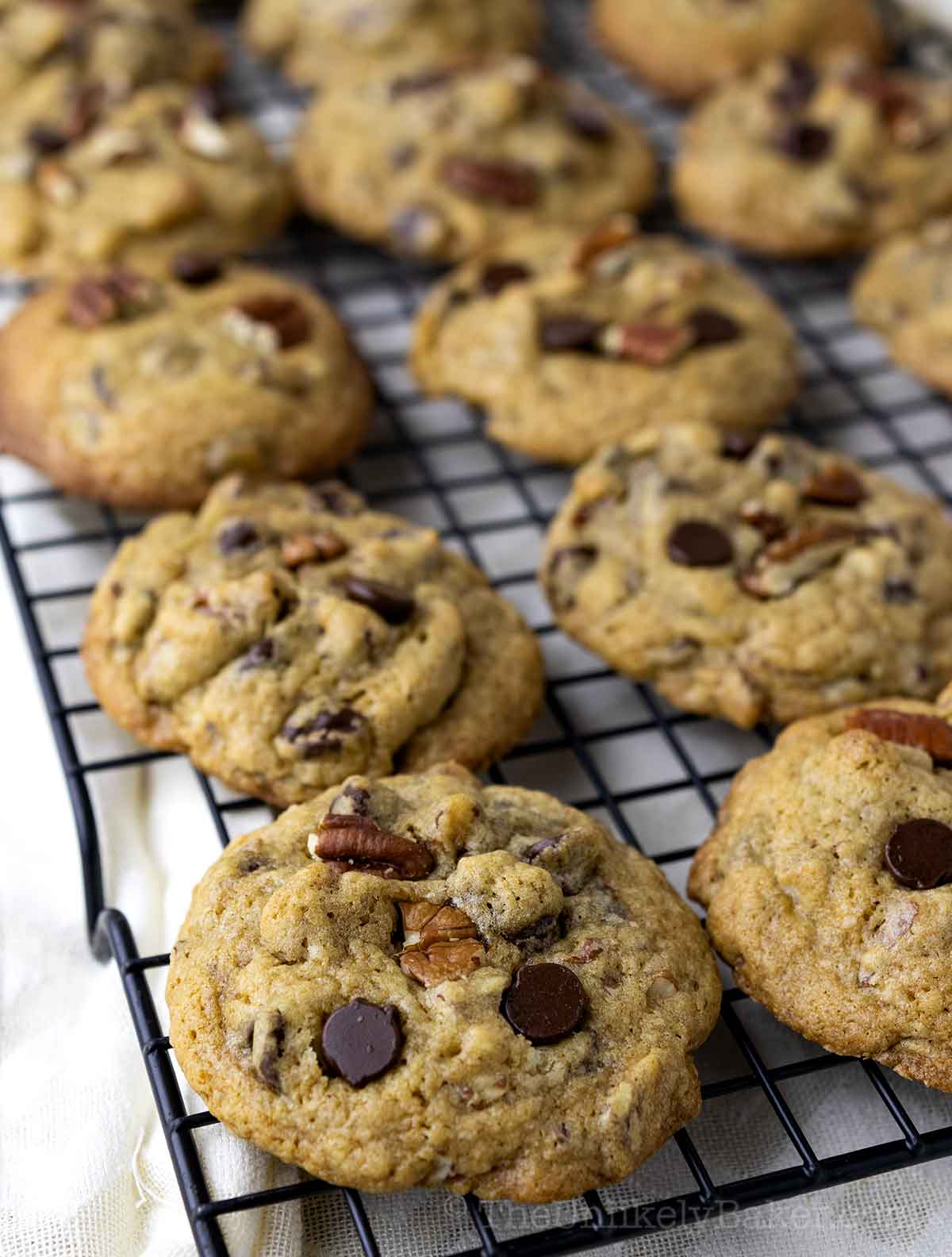 Freshly baked pecan cookies cooling on a wire rack.