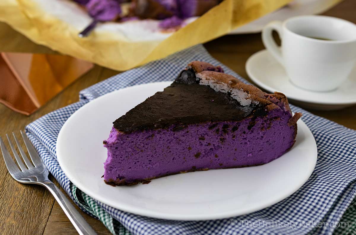 A slice of basque burnt ube cheesecake on a plate.