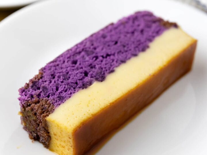 A slice of ube cake flan on a plate.