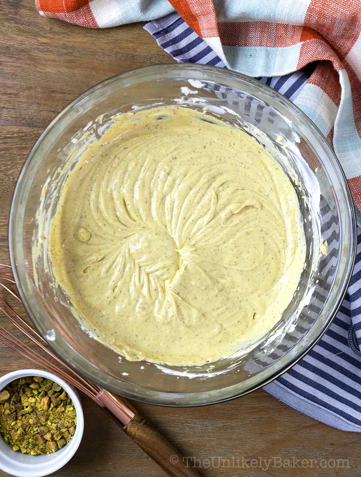 Pistachio cheesecake batter in a bowl.