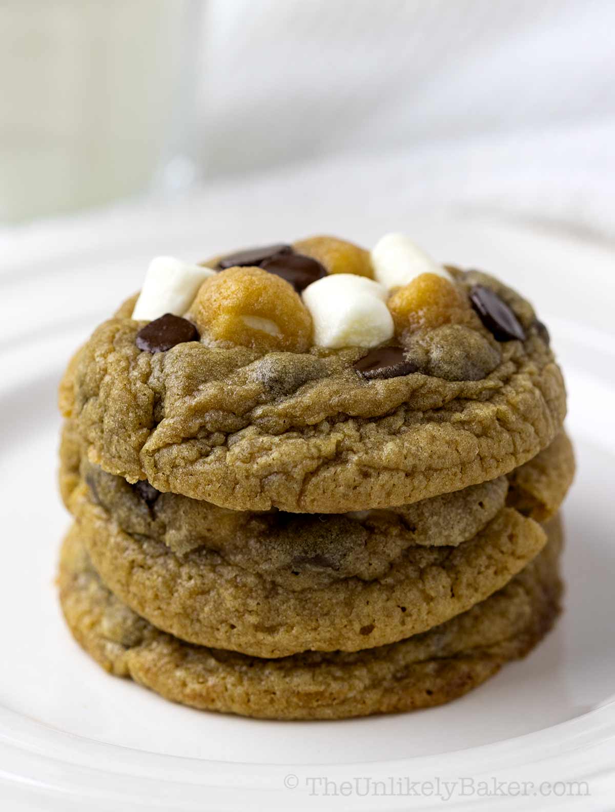 A stack of chocolate cookies marshmallows on a plate.