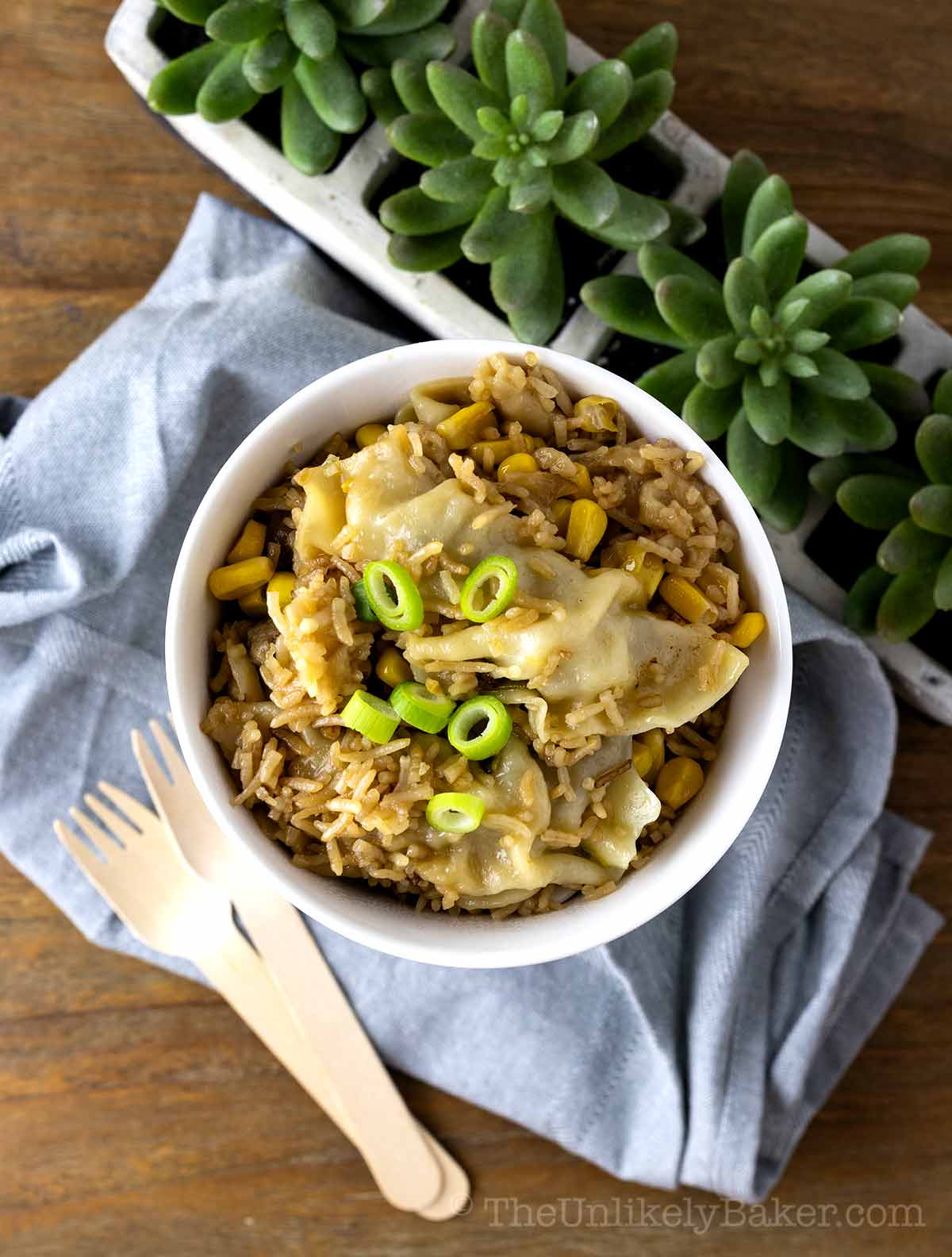 Korean mandu rice in a bowl with wooden forks beside.