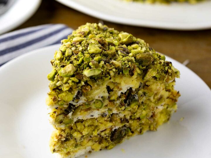 A slice of pistachio sans rival on a plate.