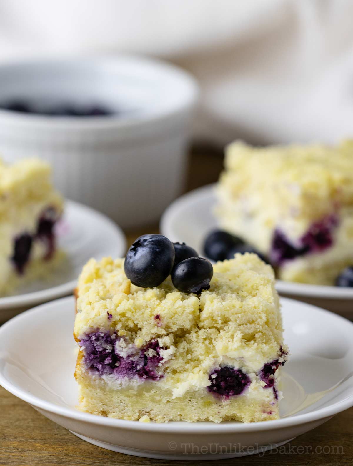 A slice of blueberry cream cheese bars on a plate.