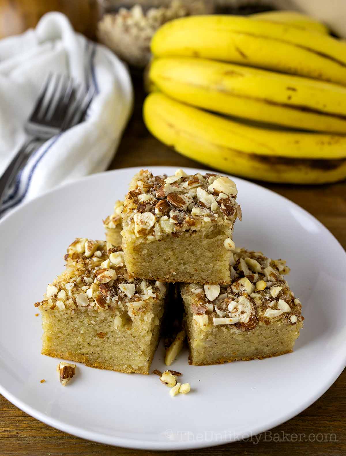 Banana mochi bread with bananas in the background.