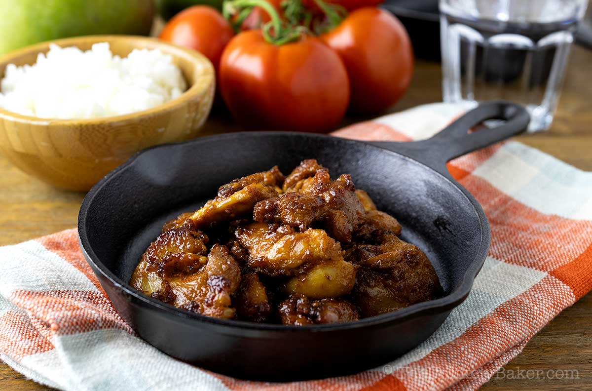 Filipino chicken tocino with rice and tomatoes in the background.