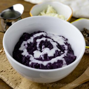 A bowl of ube champorado drizzled with milk.