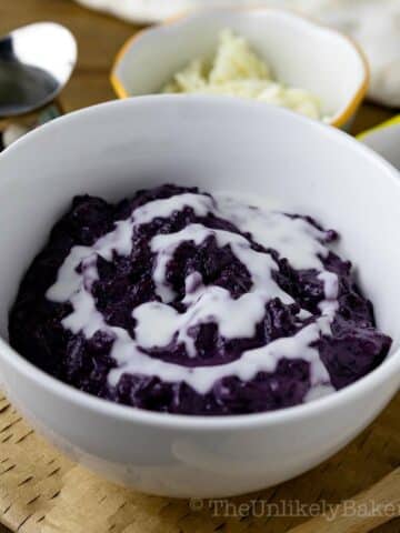 A bowl of ube champorado drizzled with milk.