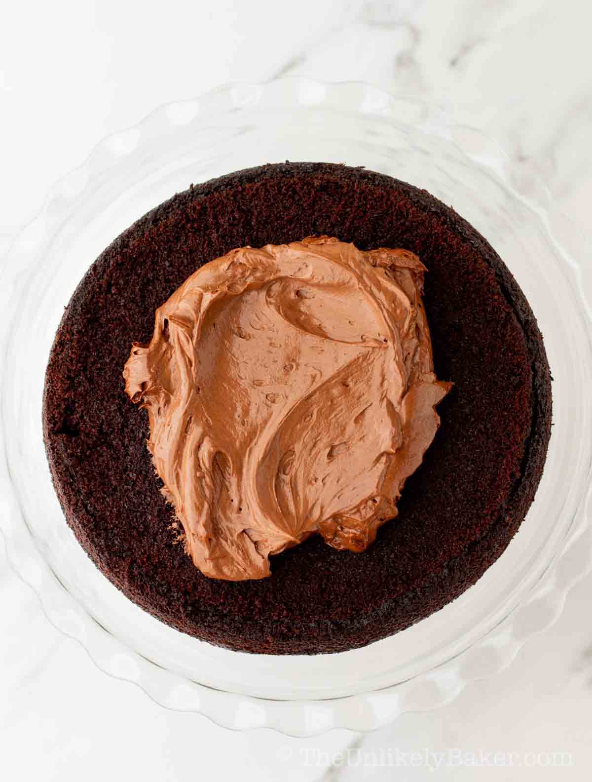 Chocolate fudge frosting on top of chocolate cake.