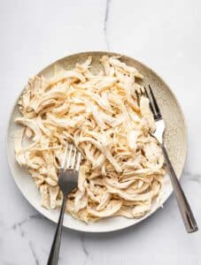 Shredded cooked chicken on a plate.