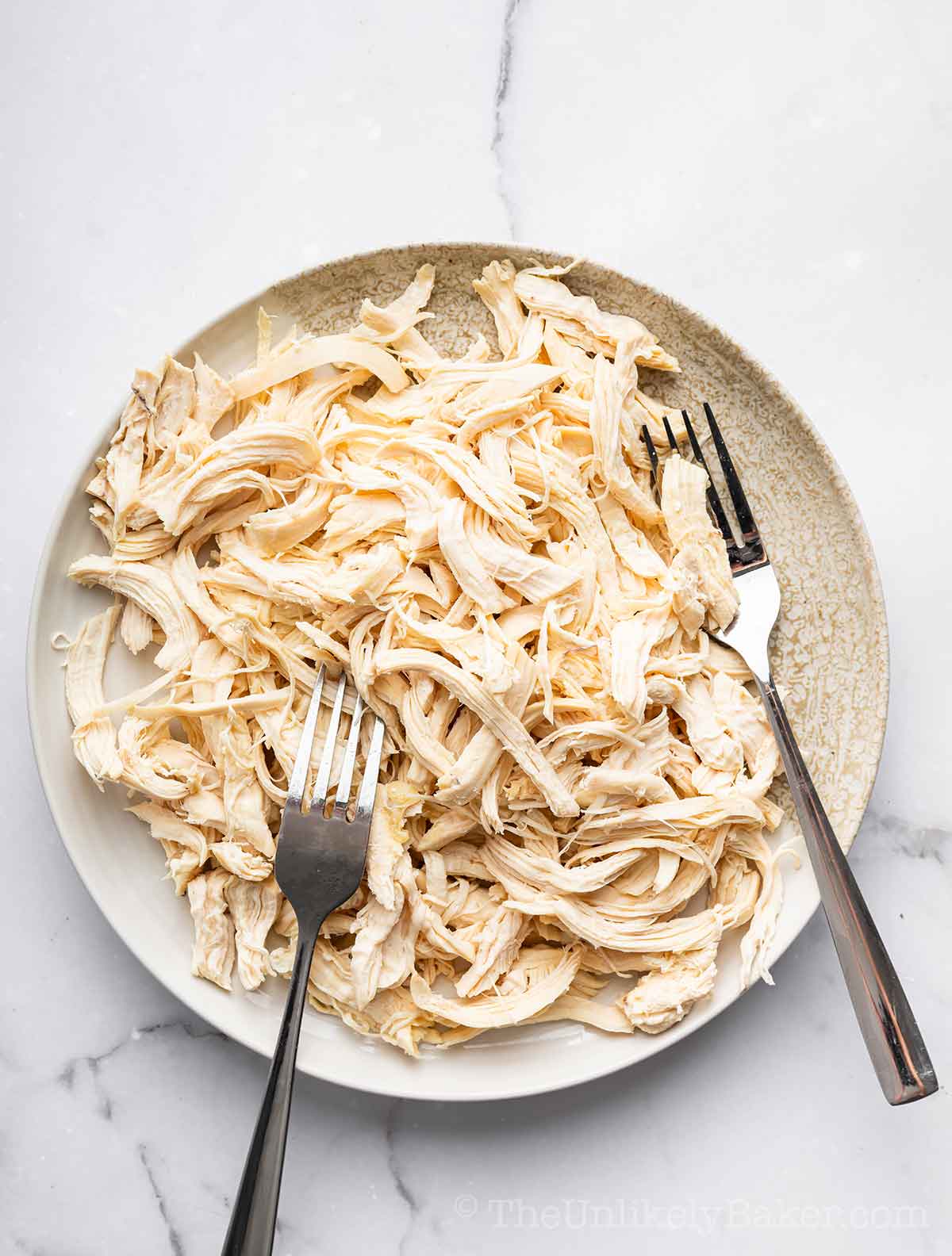 Shredded cooked chicken on a plate.