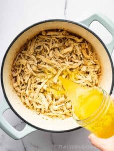 Chicken broth added to shredded chicken.