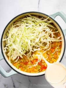 Cabbage and evaporated milk added to pot.