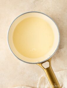 Warm cream in a pot.