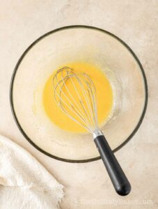 Egg yolks and sugar in a bowl.