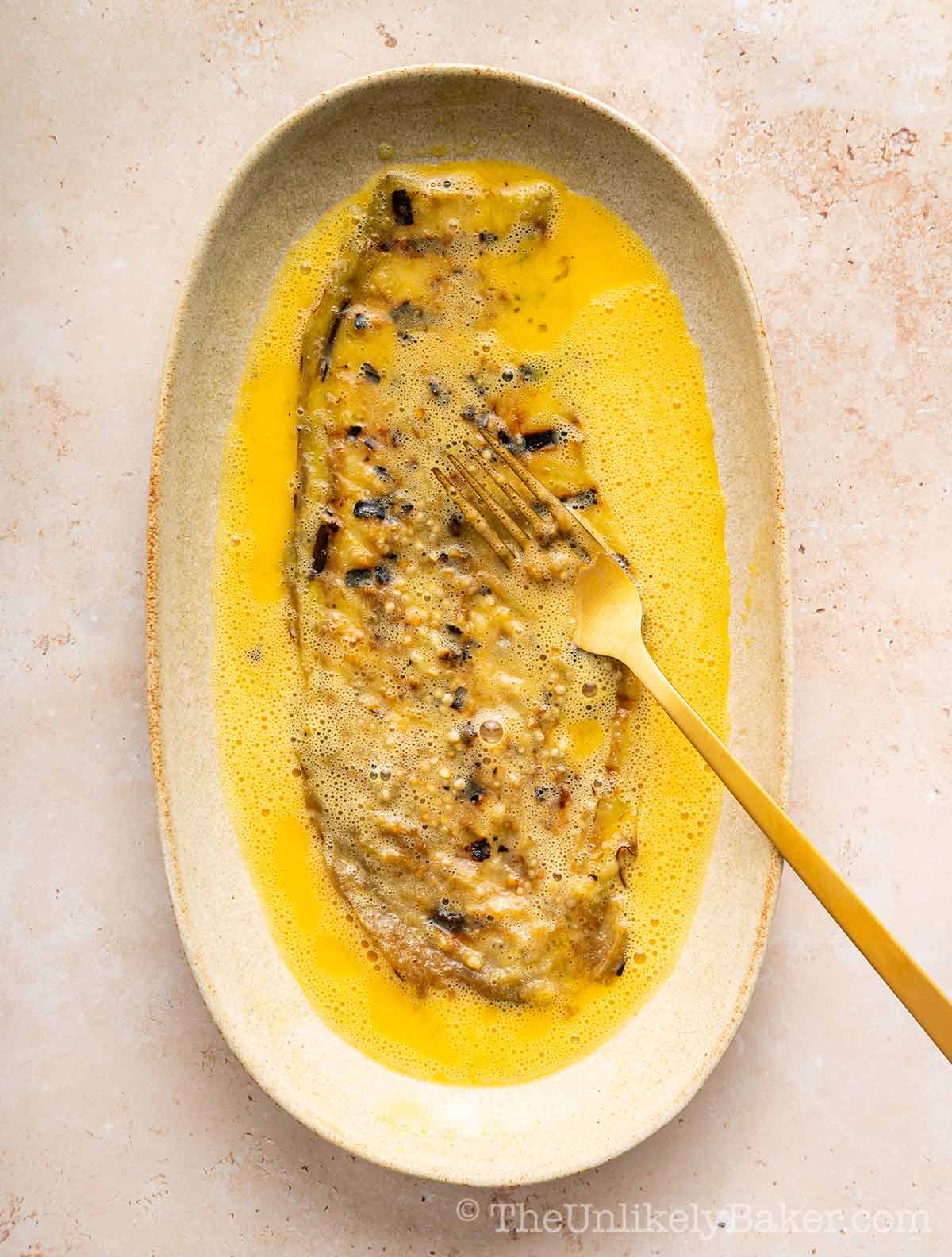 Flattened eggplant in beaten eggs.