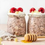 Raspberry and white chocolate oats topped with fresh raspberries.