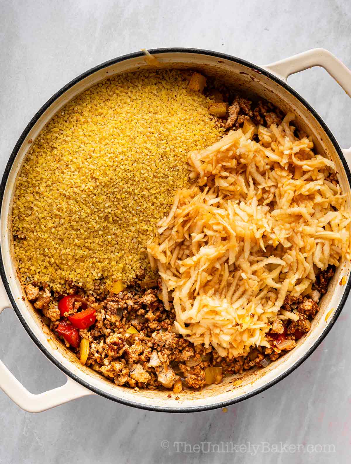 Coarse bulgur and shredded apples added to pot.
