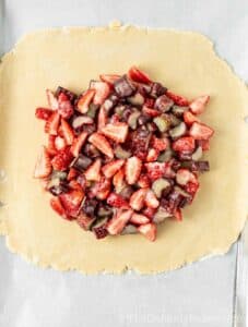 Fruit filling on rolled out pie dough.