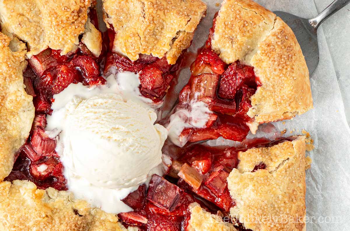 Rustic strawberry rhubarb galette topped with ice cream.