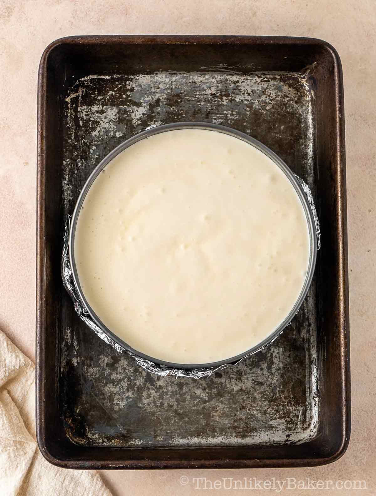 Cheesecake batter in a cake pan.