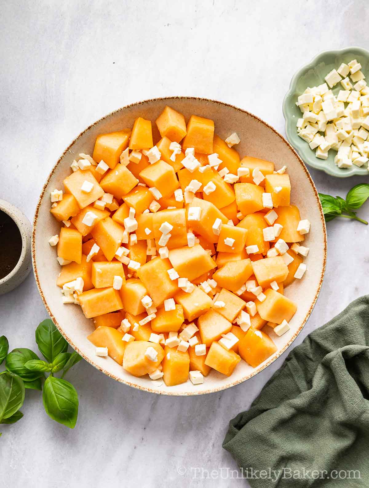 Crumbled feta cheese sprinkled on top of cantaloupe.