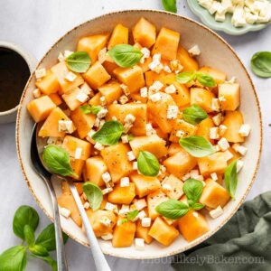 Cantaloupe salad with feta cheese in a bowl.
