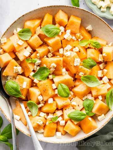 Cantaloupe salad with feta cheese in a bowl.