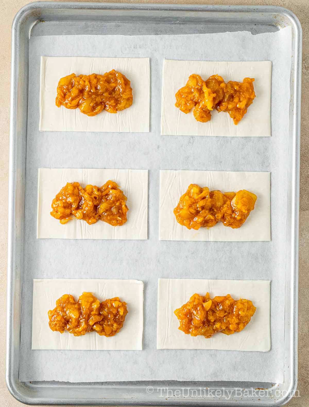 Fruit filling scooped onto pie crust.