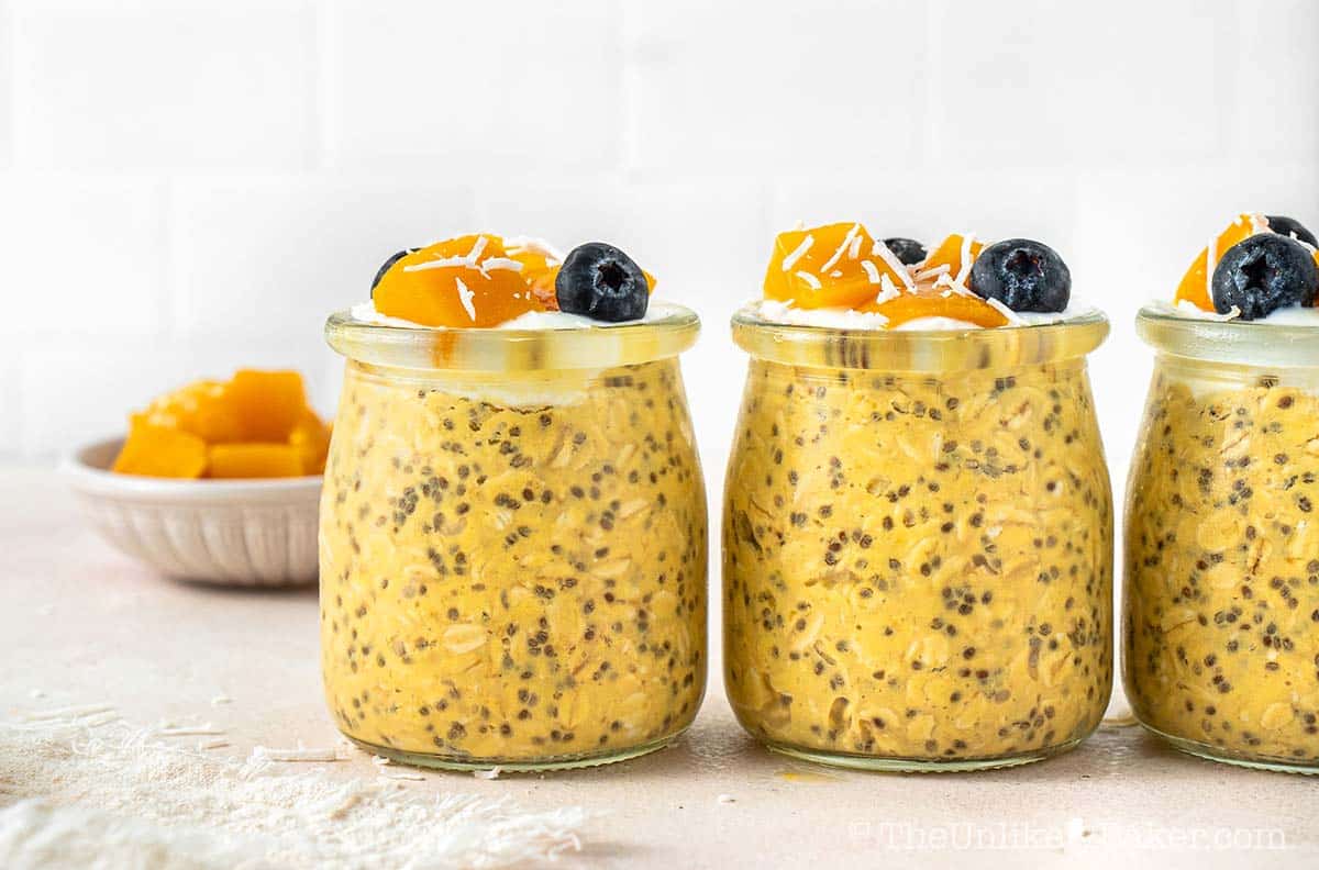 Mango overnight oats with yogurt in individual containers.