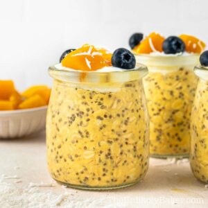 Mango overnight oats topped with diced mangoes and blueberries.