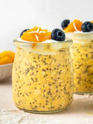 Mango overnight oats topped with diced mangoes and blueberries.