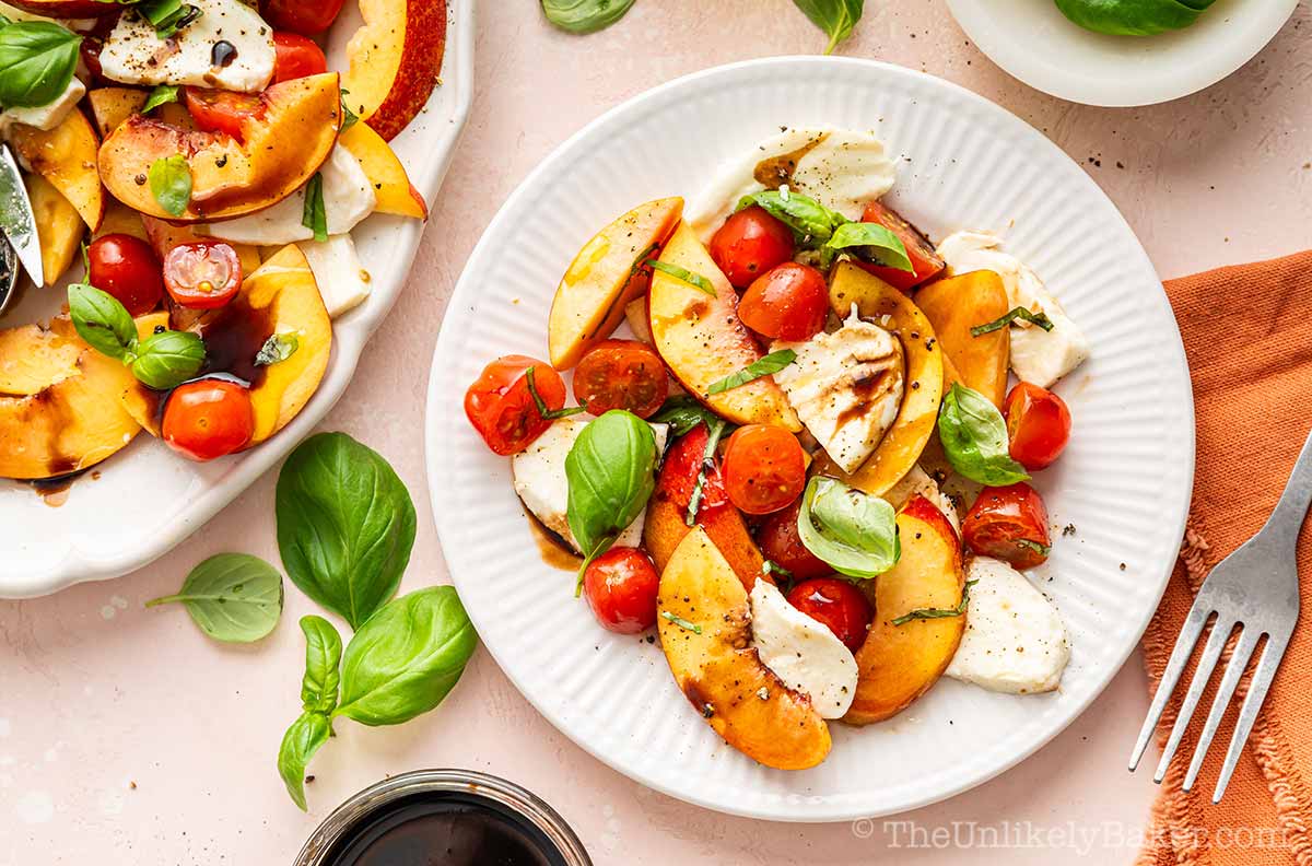Peach and tomato caprese salad on a plate.