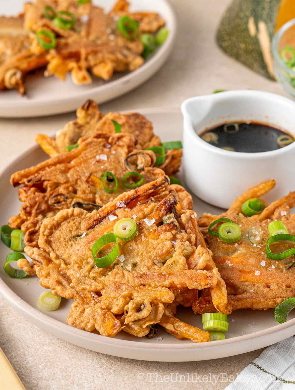 Kalabasang okoy on a plate with dipping sauce.