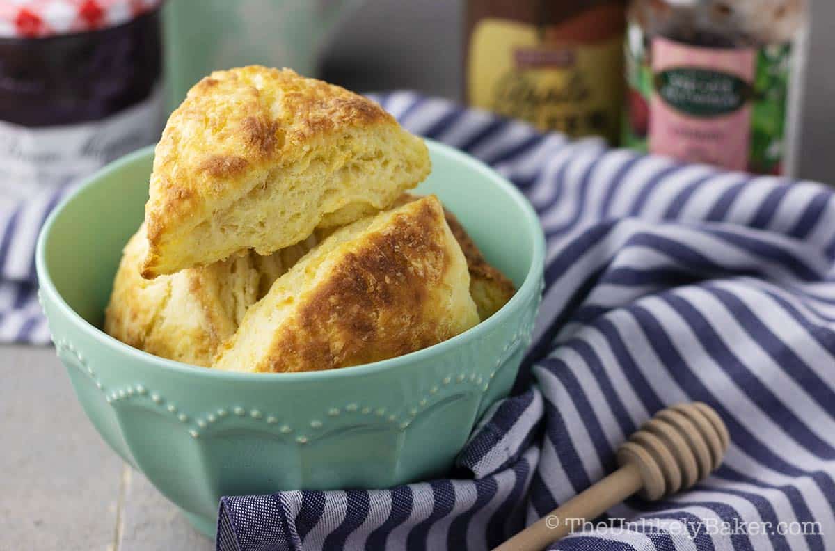 Flaky easy-to-make classic buttermilk scones with fruit jams in the background.